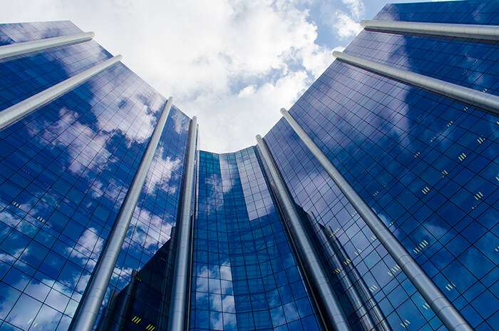 Fachada espelhada da sede da Petrobras, com nuvens ao fundo
